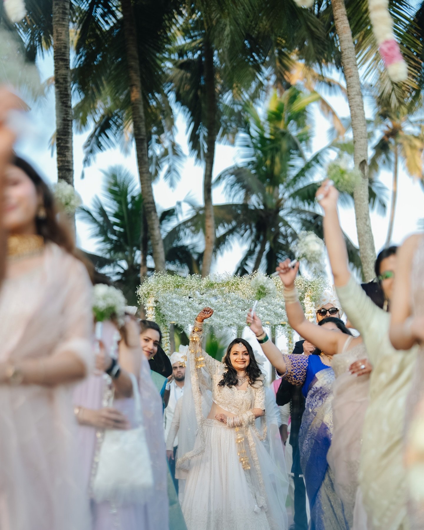 A bride making a joyful grand entrance under a floral canopy